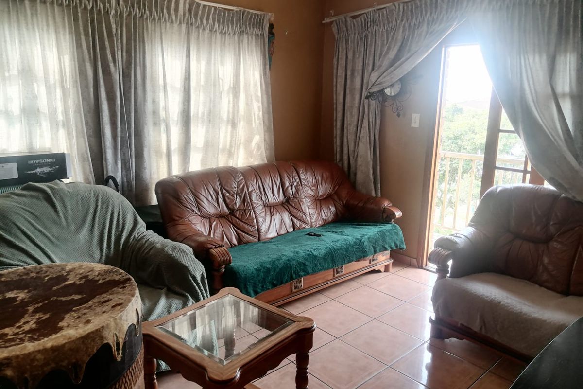 A living room featuring tiled flooring and a sliding glass door providing access to an outdoor area.