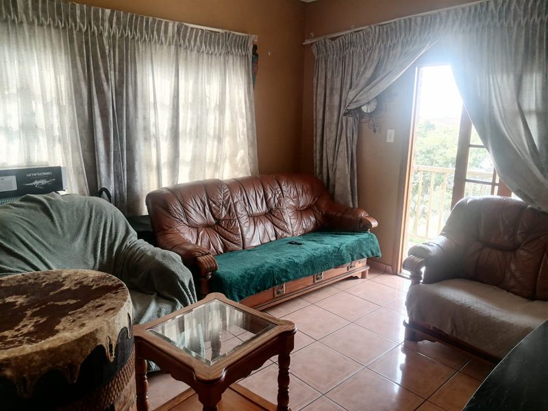 A living room featuring tiled flooring and a sliding glass door providing access to an outdoor area.