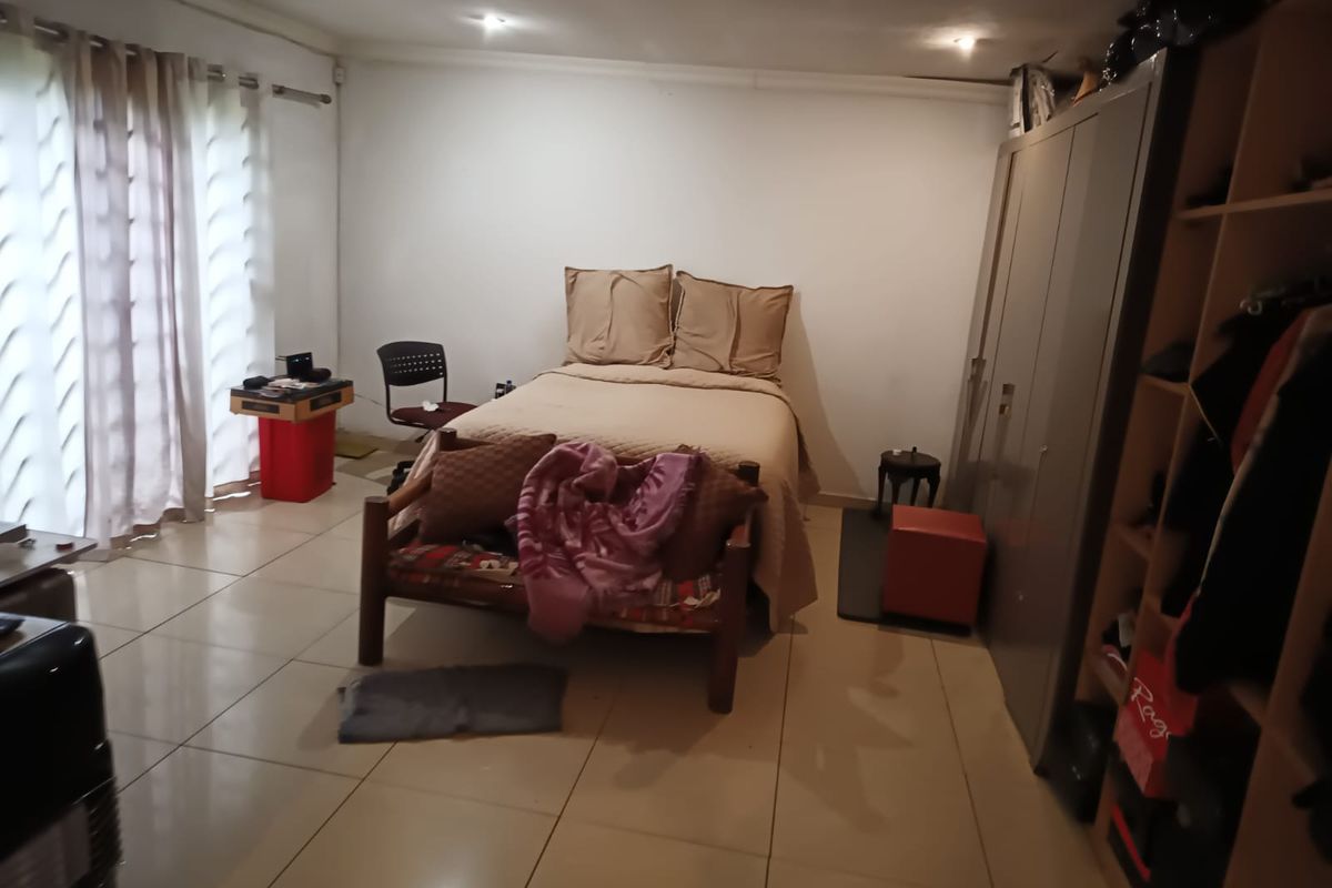 A functional bedroom featuring tiled flooring, recessed ceiling lighting, and a built-in wardrobe, offering a neutral base for personalization.