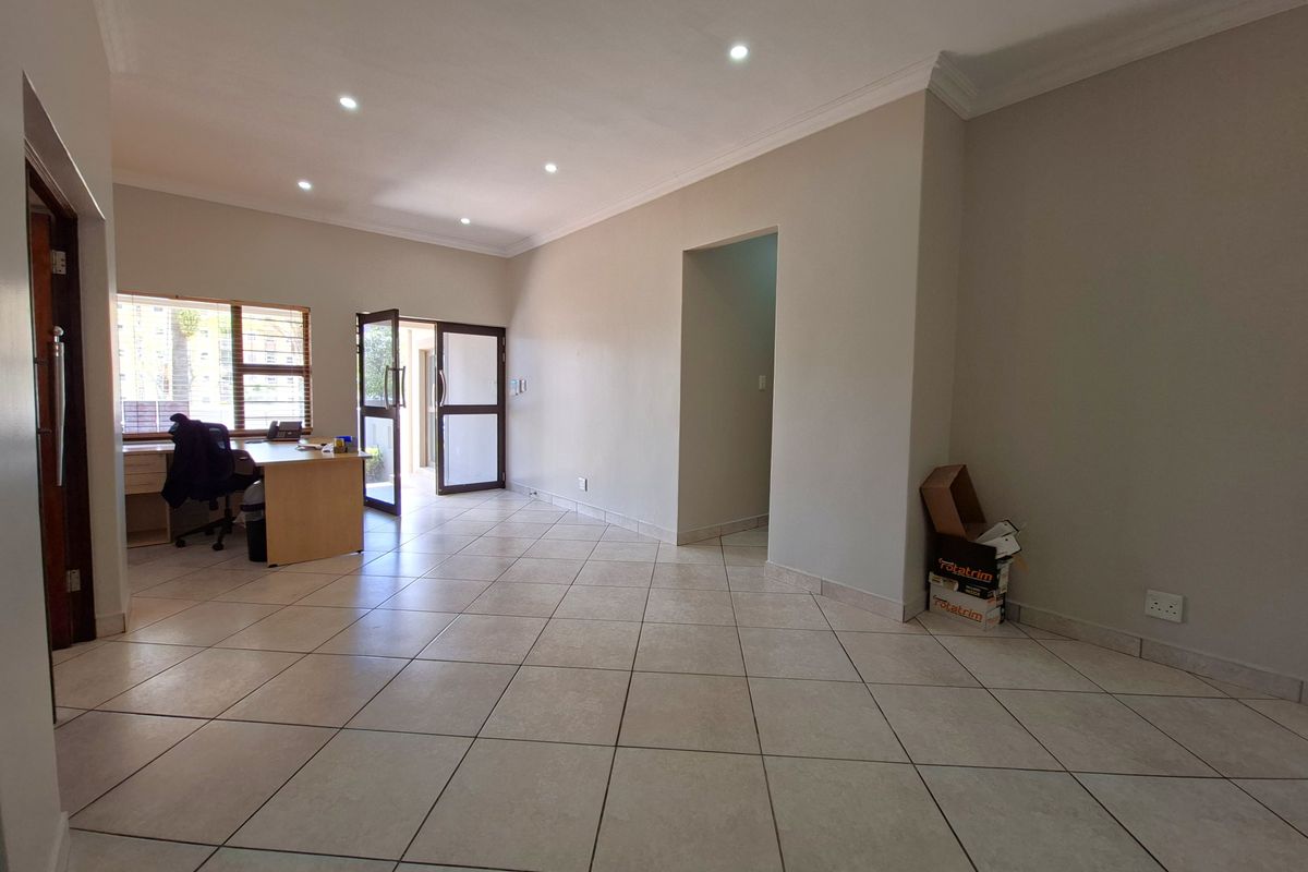 Spacious living area featuring neutral ceramic floor tiles, recessed downlighting, and coved cornicing, providing a clean and versatile space for various interior layouts.