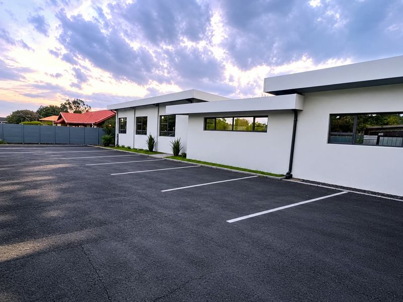 A modern exterior view of the property featuring a clean, paved parking area and well-maintained building facade with contemporary architectural lines.