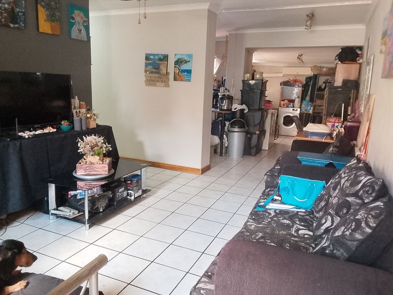 Open plan living area featuring tiled flooring and a connected utility space, offering a functional layout for daily living.