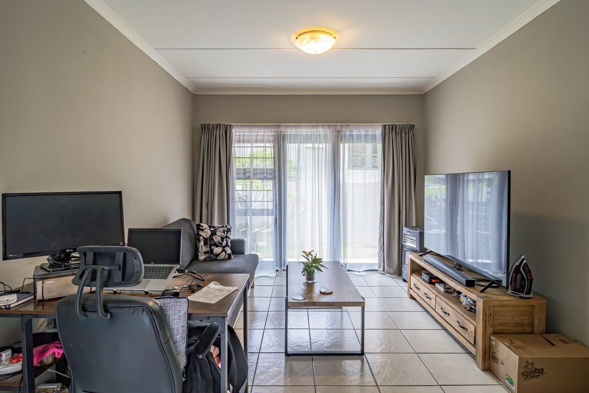A functional living room featuring tiled flooring and a sliding glass door that provides access to the exterior.