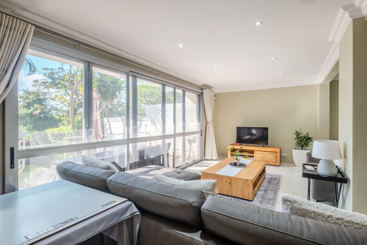 Bright and spacious living room featuring large sliding glass doors that provide ample natural light and direct access to the outdoor area.