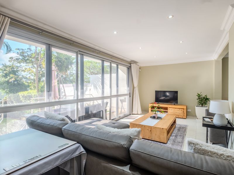Bright and spacious living room featuring large sliding glass doors that provide ample natural light and direct access to the outdoor area.