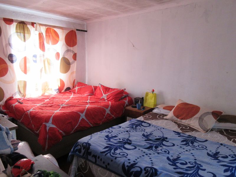 A bedroom space featuring visible wear on the ceiling and walls, requiring cosmetic updates to improve the overall condition and appeal.