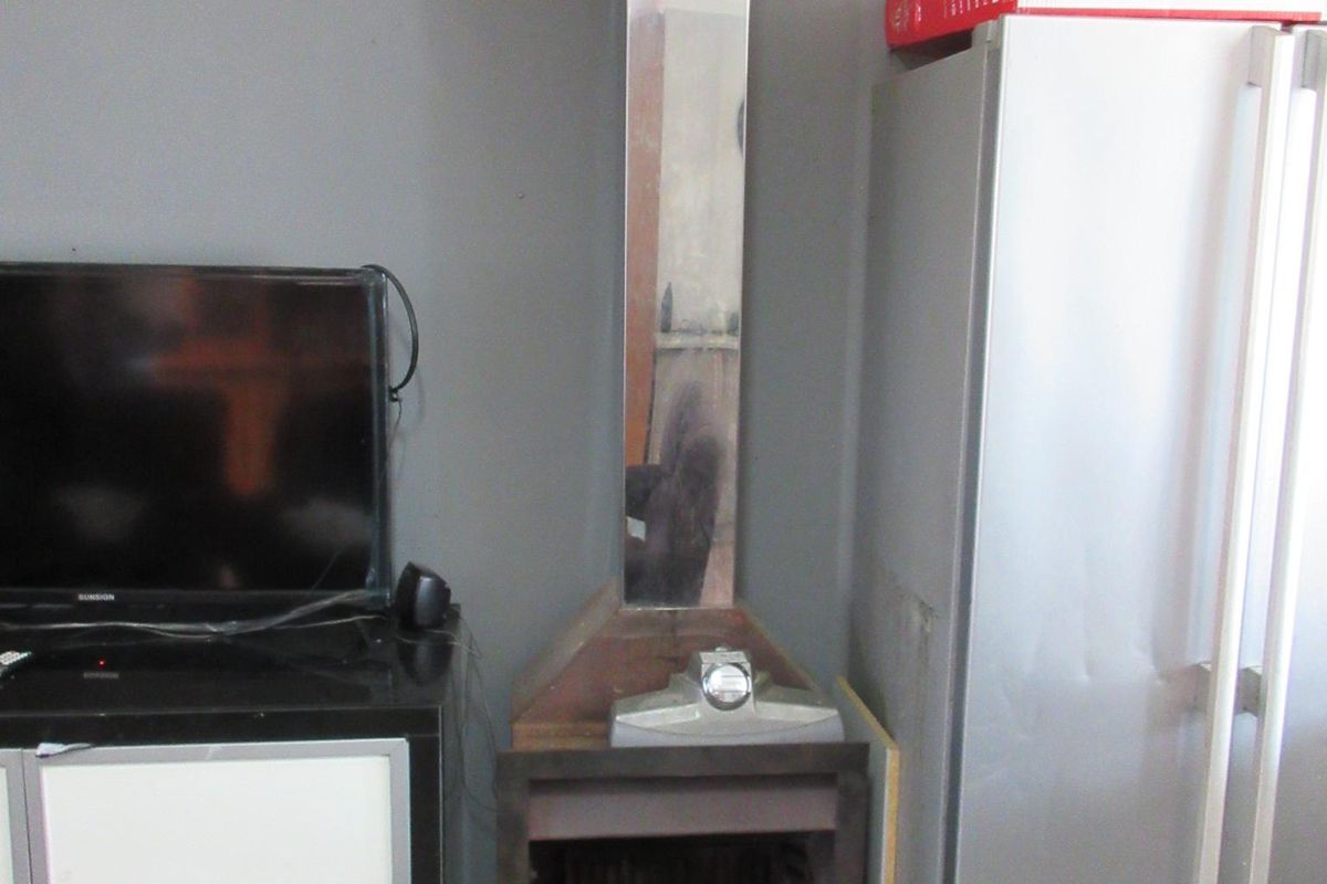 Living area featuring a built-in fireplace with a stainless steel flue and tiled flooring, requiring cosmetic updates to improve the overall aesthetic.