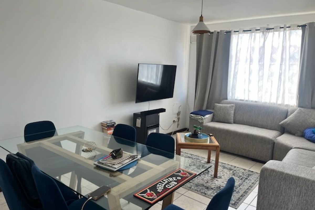Open plan living and dining area featuring tiled flooring and neutral walls, providing a functional space for relaxation and meals.