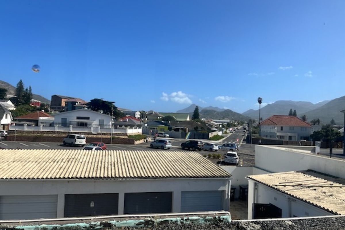 Elevated view overlooking the surrounding neighborhood, street, and distant mountain range from the property.