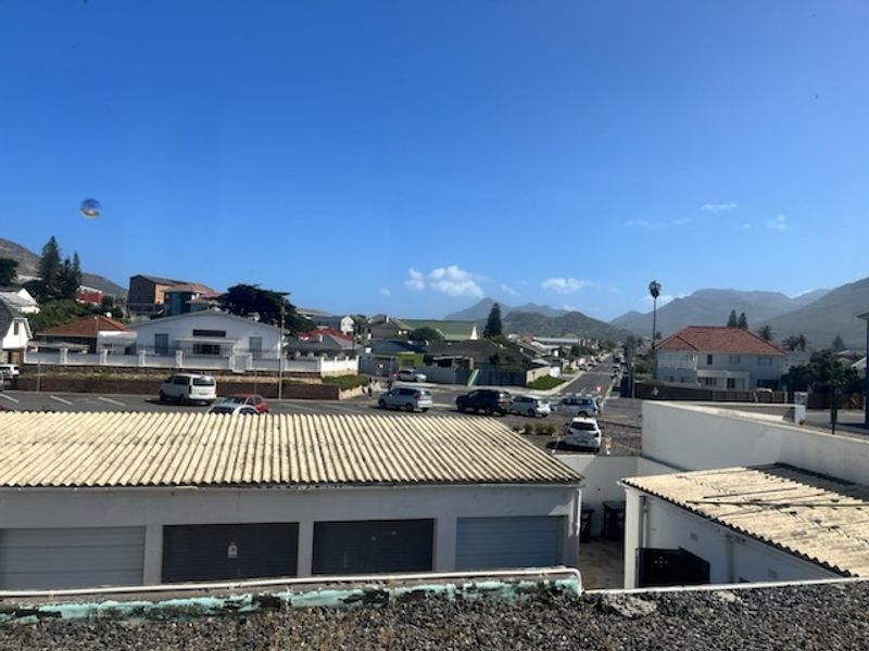 Elevated view overlooking the surrounding neighborhood, street, and distant mountain range from the property.