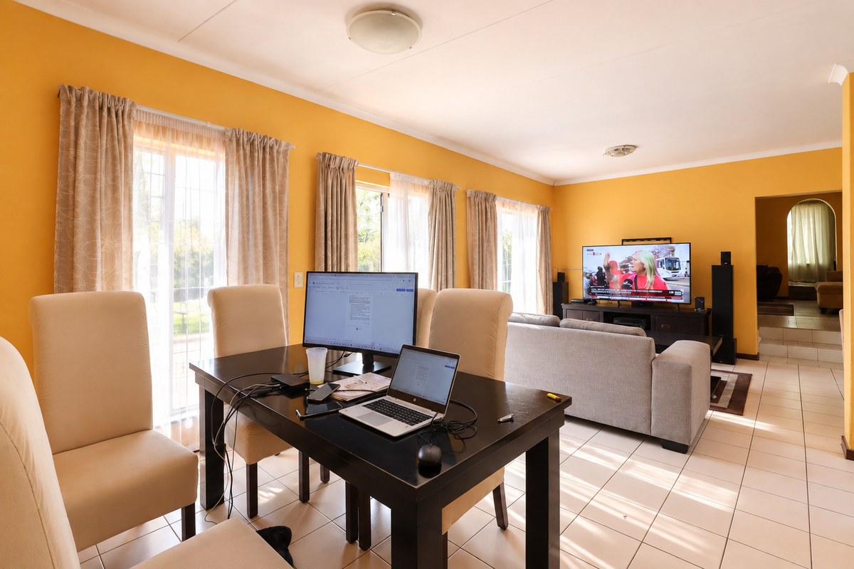 A spacious living area featuring tiled flooring, large sliding glass doors for natural light, and an arched entryway leading to an adjacent room.