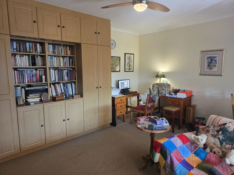 A bedroom featuring extensive built-in wooden cabinetry and a ceiling fan, offering ample storage space.