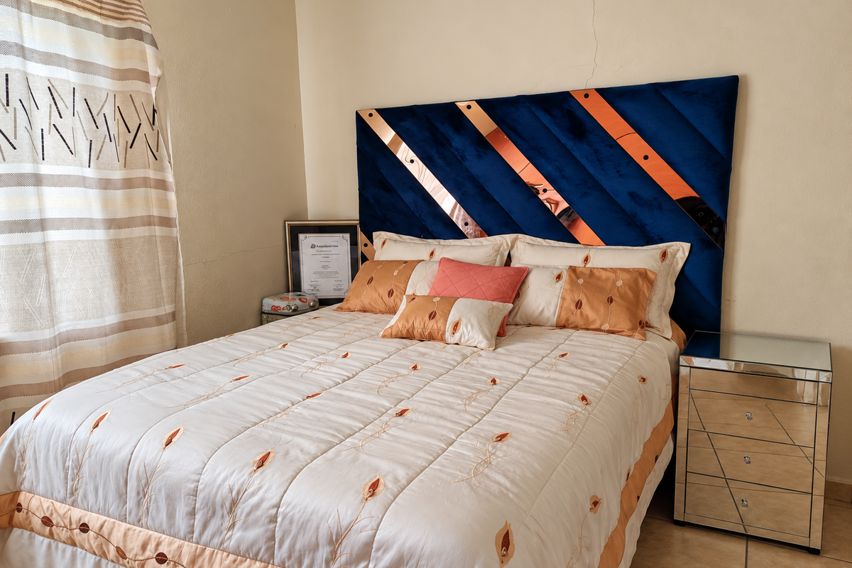 A bedroom featuring tiled flooring and a prominent wall crack above the headboard area.