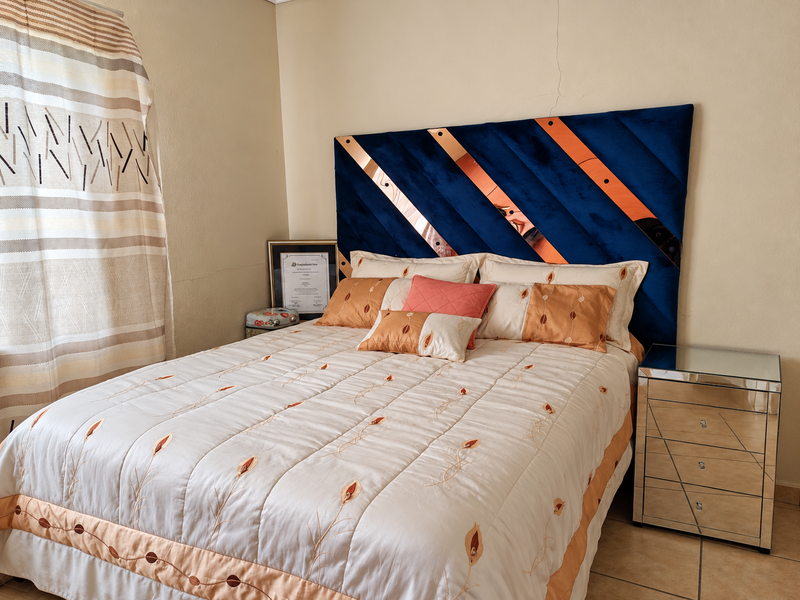 A bedroom featuring tiled flooring and a prominent wall crack above the headboard area.
