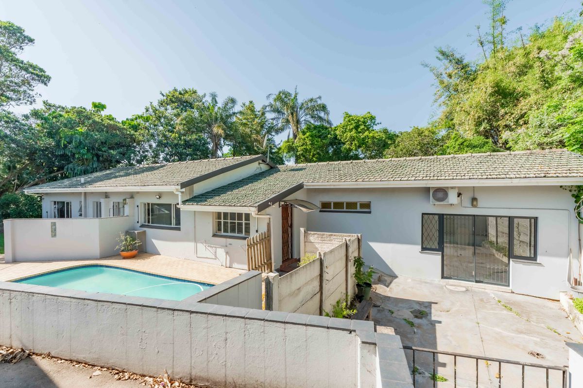 Rear view of the property featuring a swimming pool, paved patio area, and direct access via sliding glass doors to the main dwelling.