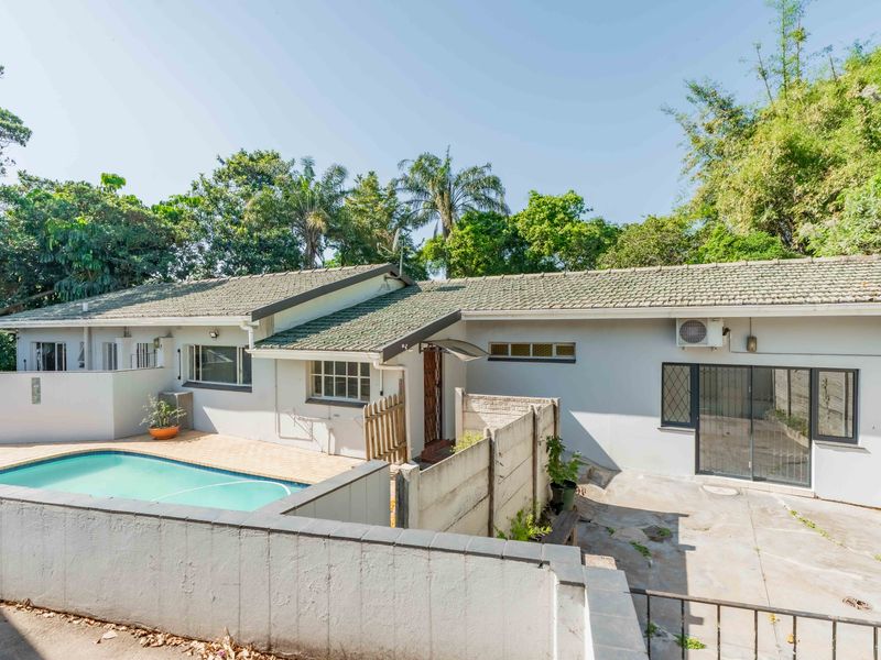 Rear view of the property featuring a swimming pool, paved patio area, and direct access via sliding glass doors to the main dwelling.