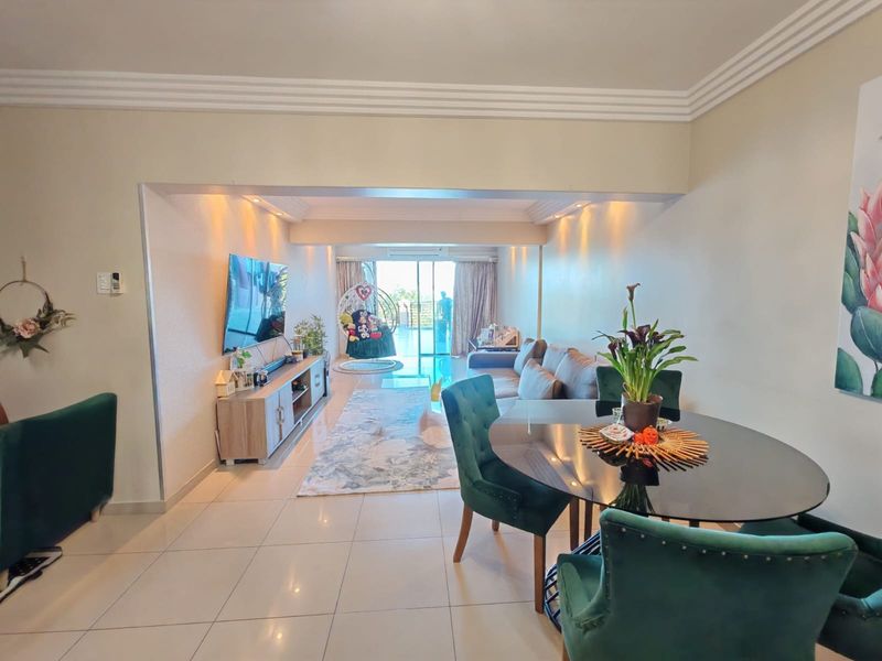 Spacious open-plan living and dining area featuring tiled flooring, recessed lighting, and direct access to a balcony through large sliding glass doors.