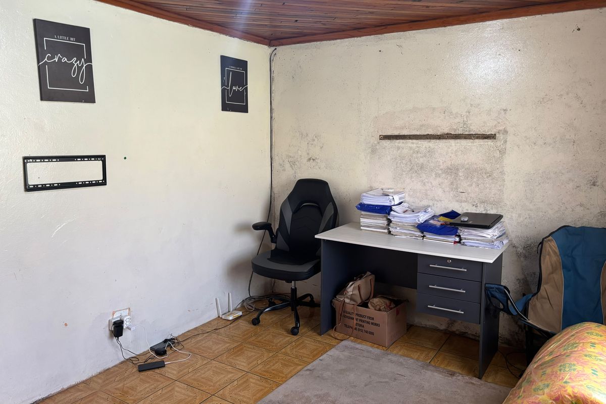 A small office space featuring timber ceiling panels and tiled flooring, currently requiring significant wall repairs and cosmetic refurbishment.