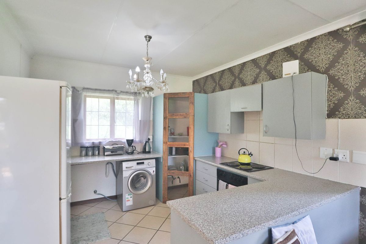 Functional kitchen featuring built-in cabinetry, laminate countertops, tiled backsplash, and integrated appliances, offering a practical layout with potential for modern updates.