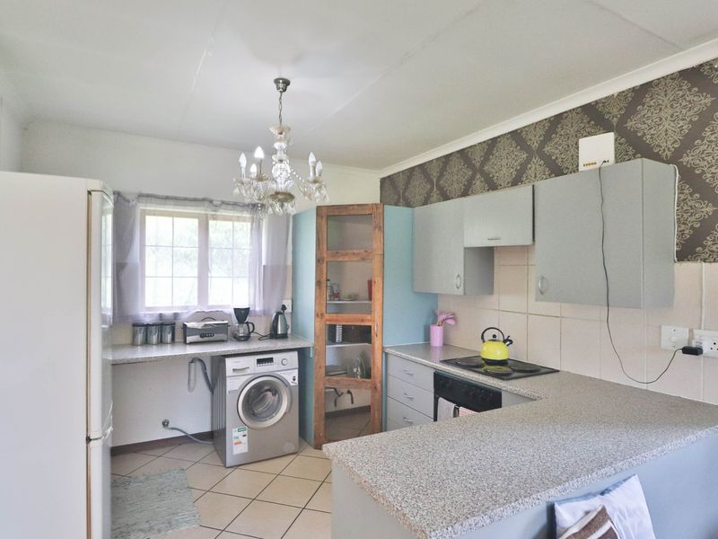 Functional kitchen featuring built-in cabinetry, laminate countertops, tiled backsplash, and integrated appliances, offering a practical layout with potential for modern updates.