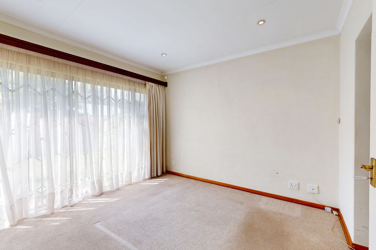 A vacant bedroom featuring neutral walls, carpet flooring, recessed lighting, and a large sliding door providing access to the exterior.