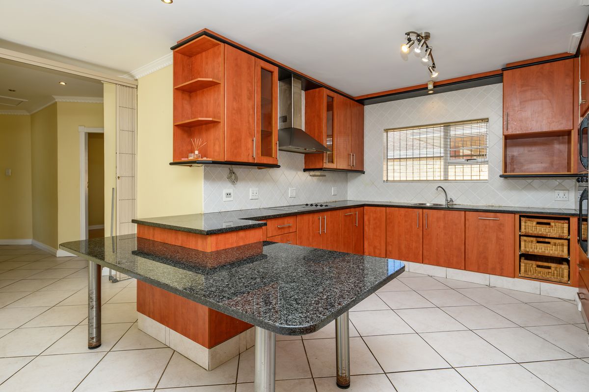 Spacious kitchen featuring granite countertops, ample built-in cabinetry, a breakfast bar, and integrated stainless steel appliances, offering a functional layout for cooking and dining.