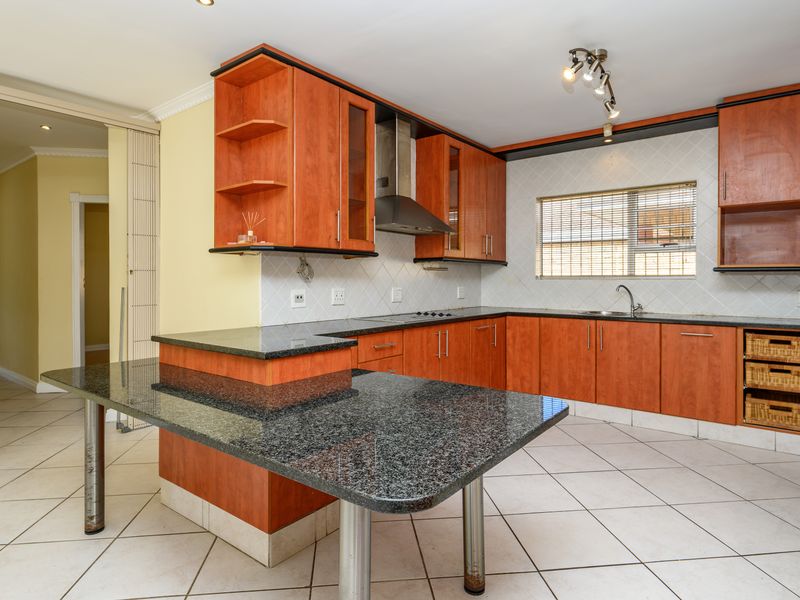 Spacious kitchen featuring granite countertops, ample built-in cabinetry, a breakfast bar, and integrated stainless steel appliances, offering a functional layout for cooking and dining.