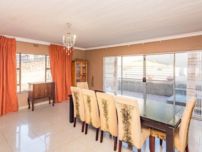 Spacious dining room featuring tiled flooring, a timber-look ceiling, and large sliding glass doors that provide direct access to the outdoor patio area.