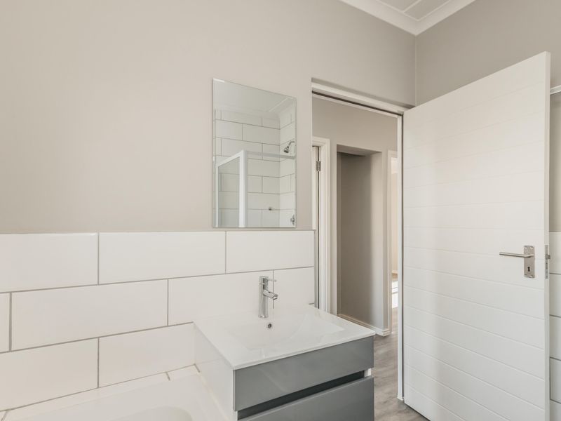 Modern bathroom featuring a sleek vanity with basin, subway tile splashback, and neutral wall finishes.