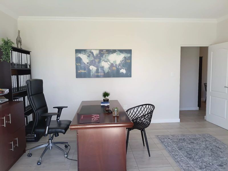 A well-maintained office space featuring neutral wall tones, tiled flooring, and coved ceiling detailing, providing a professional and functional work environment.