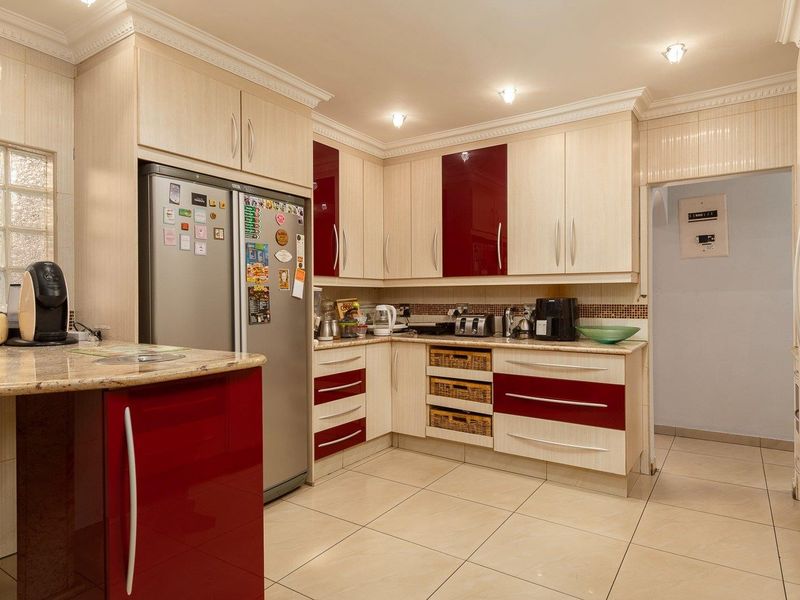 A well-maintained kitchen featuring two-tone cabinetry, granite countertops, tiled flooring, and recessed lighting, offering a functional and organized culinary space.