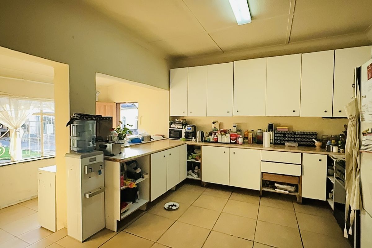 A functional kitchen featuring built-in cabinetry, tiled flooring, and ample counter space, offering significant potential for modernization and aesthetic upgrades.