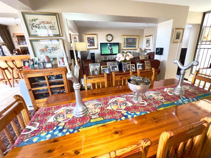 Open plan living and dining area featuring a breakfast bar and built-in cabinetry, offering a functional layout for family living and entertaining.