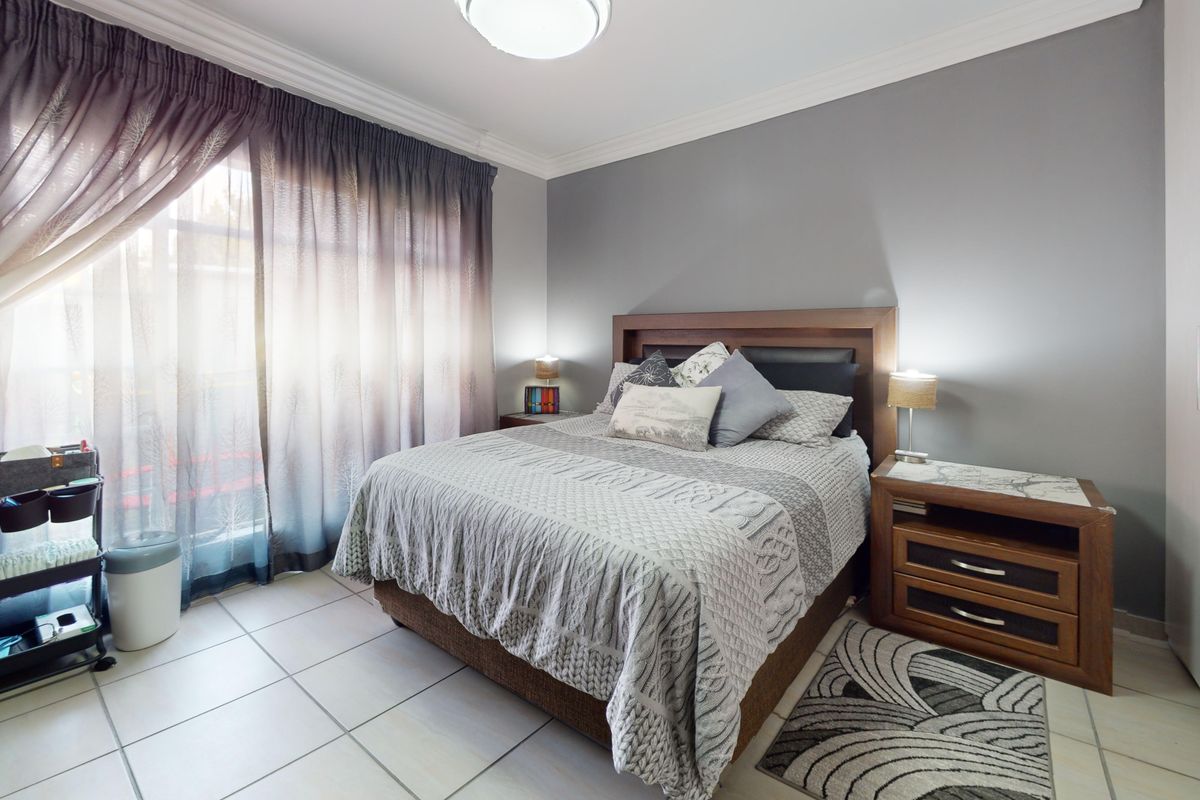 A well-maintained bedroom featuring tiled flooring, a built-in wardrobe, and decorative ceiling cornicing, offering a comfortable and functional living space.