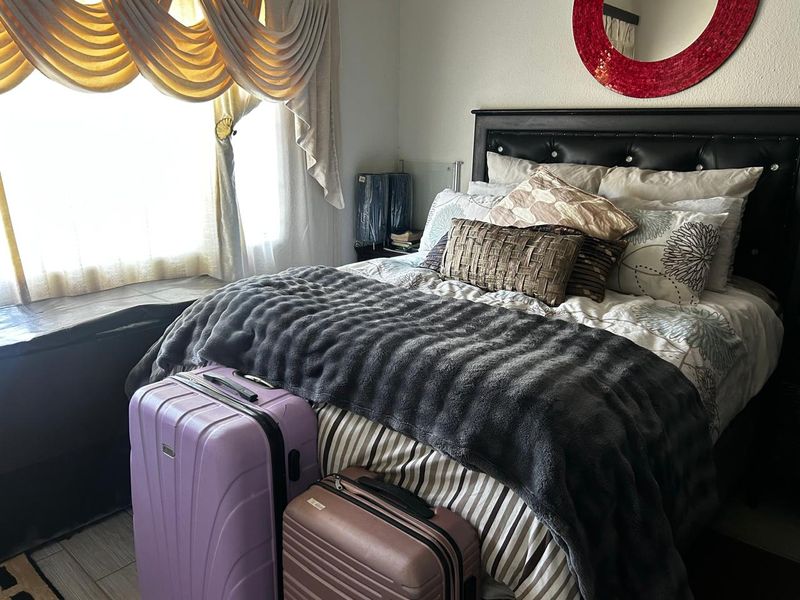 A cozy bedroom featuring a built-in window seat and neutral wall finishes, providing a comfortable sleeping space.