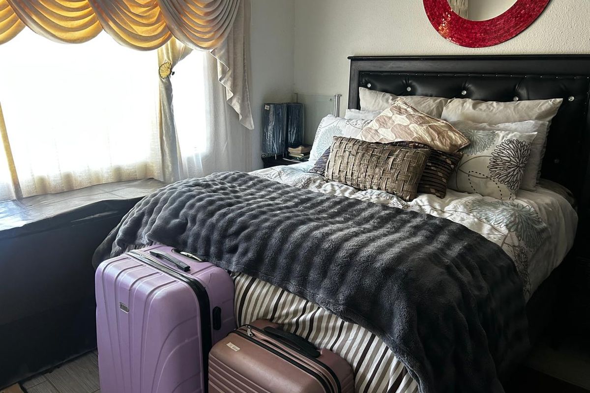 A cozy bedroom featuring a built-in window seat and neutral wall finishes, providing a comfortable sleeping space.