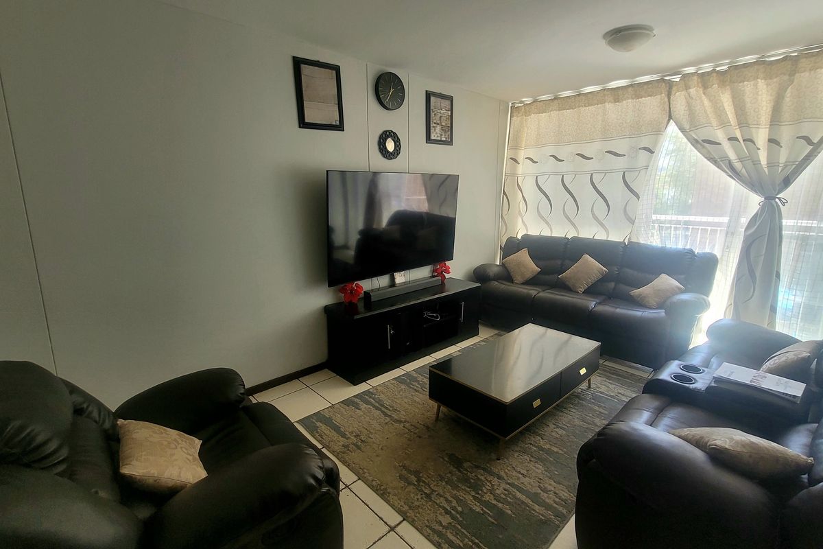 A comfortable living room featuring tiled flooring and a sliding glass door that provides access to an outdoor area.