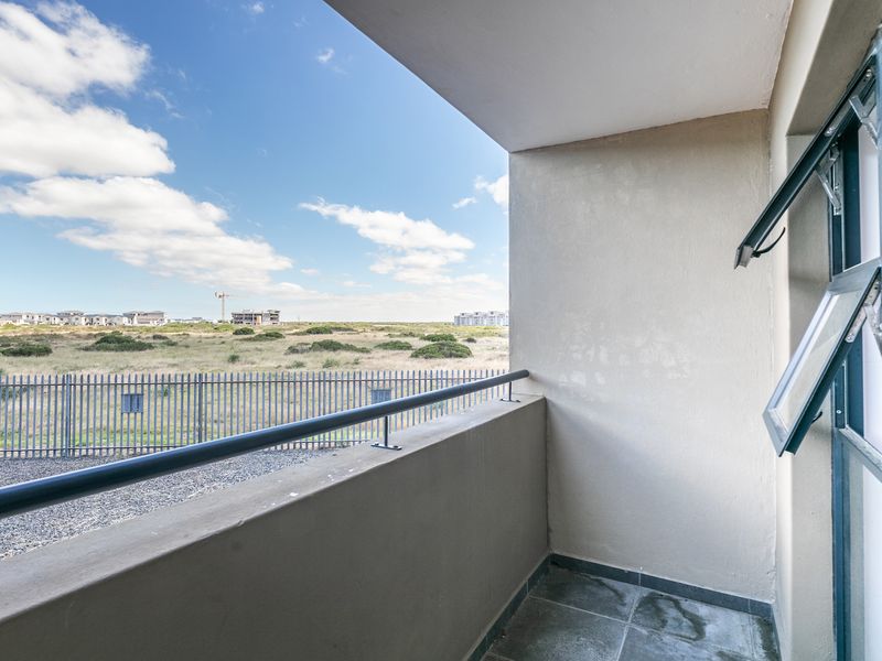 A private balcony featuring tiled flooring, a metal balustrade, and open views of the surrounding landscape.