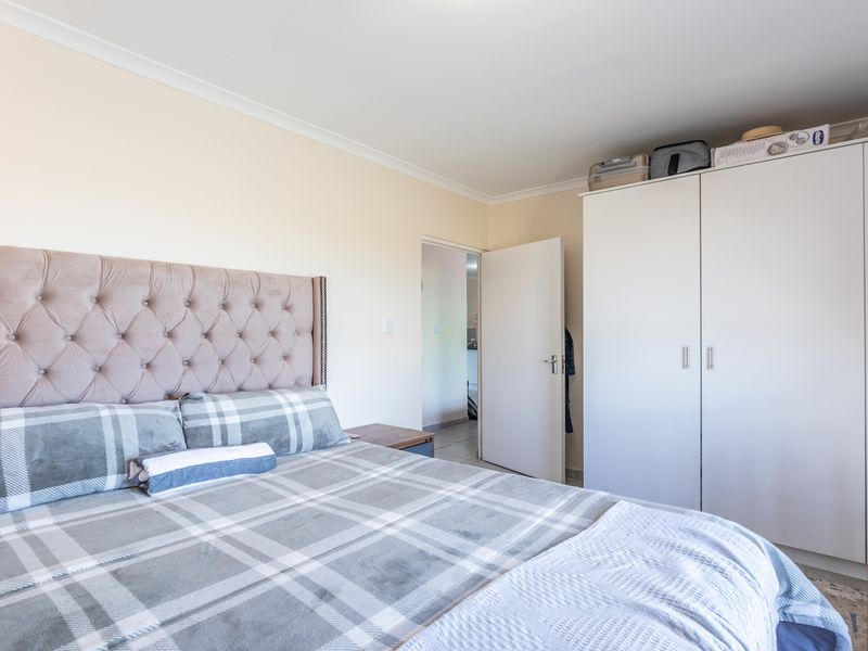 A well-maintained bedroom featuring a large built-in wardrobe and neutral wall finishes, providing a clean and functional living space.