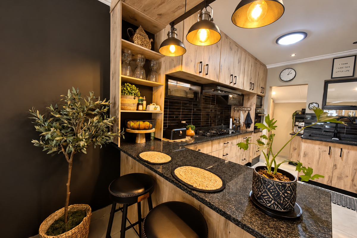 Modern kitchen featuring wood-look cabinetry, granite countertops, a breakfast bar, and integrated gas hob with stylish pendant lighting.