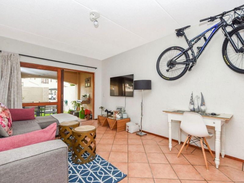 A living room featuring terracotta floor tiles and a sliding glass door providing access to an outdoor patio area.