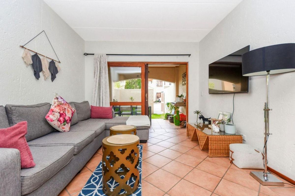 A living room featuring tiled flooring and a sliding glass door that provides access to an outdoor patio area.