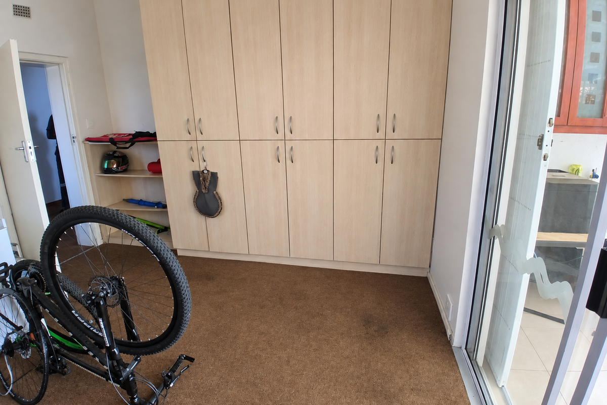 Bedroom featuring extensive built-in cabinetry, carpeted flooring, and a sliding glass door providing access to an outdoor area.
