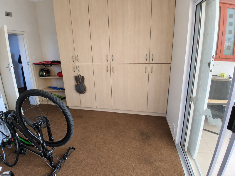 Bedroom featuring extensive built-in cabinetry, carpeted flooring, and a sliding glass door providing access to an outdoor area.