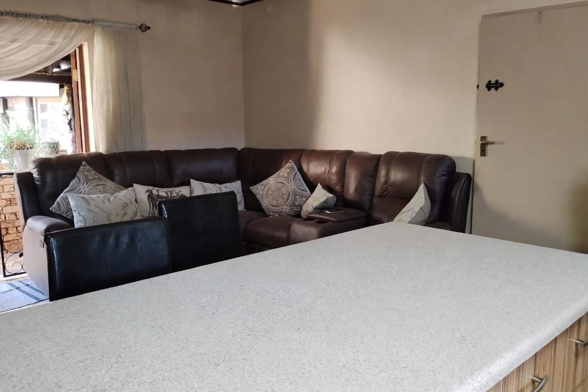 Open plan living area featuring a kitchen island with stone countertop and direct access to an outdoor patio space.