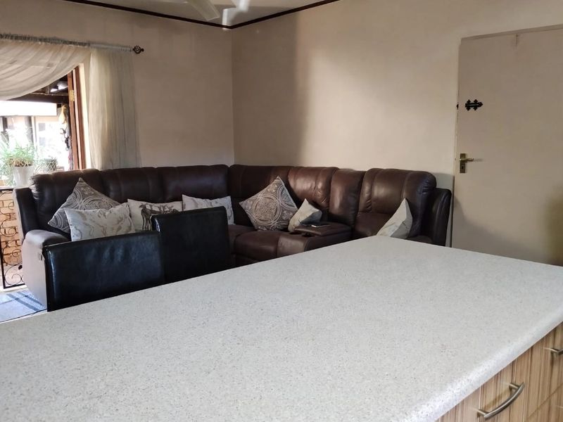 Open plan living area featuring a kitchen island with stone countertop and direct access to an outdoor patio space.