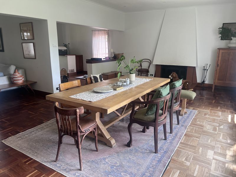 Spacious dining room featuring classic parquet flooring and a prominent built-in fireplace, creating a warm and inviting atmosphere for gatherings.