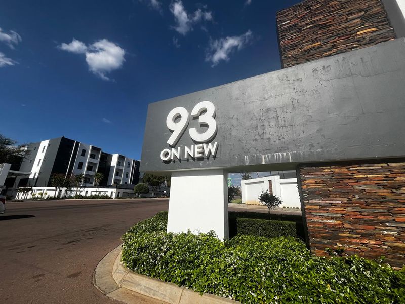 Exterior view of the 93 On New apartment complex entrance, featuring modern stone cladding and prominent signage.