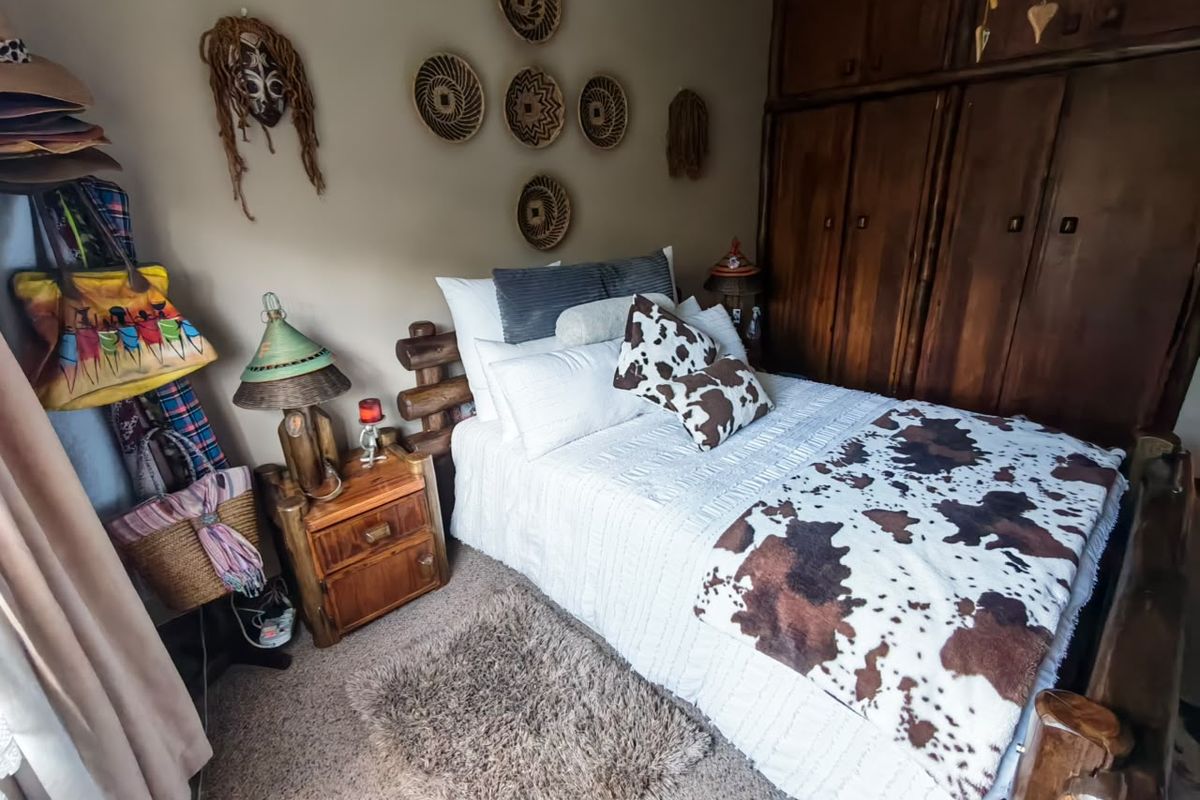 A cozy bedroom featuring built-in wooden cupboards and neutral wall tones, offering a warm and functional sleeping space.
