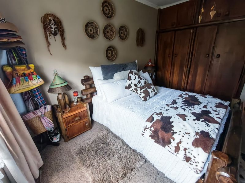 A cozy bedroom featuring built-in wooden cupboards and neutral wall tones, offering a warm and functional sleeping space.